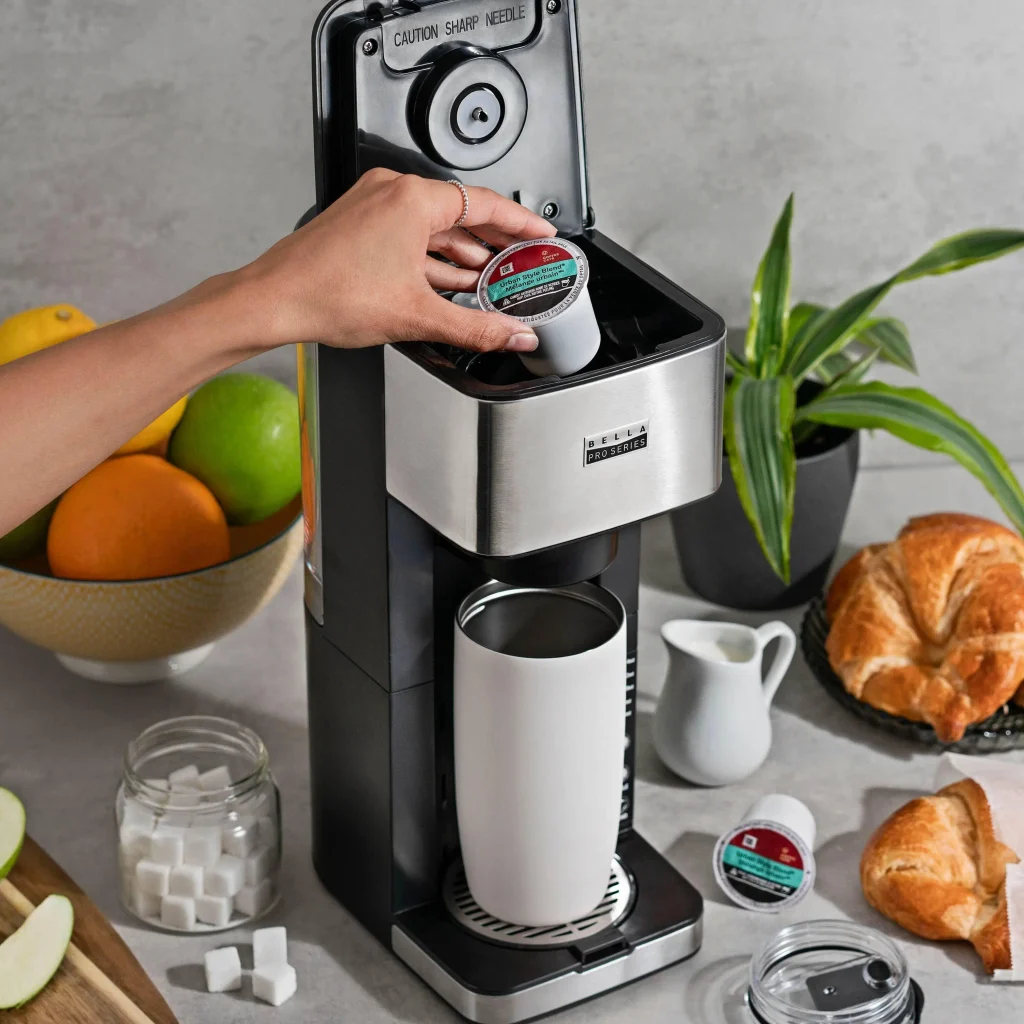 Removing a used coffee pod from a single-serve coffee machine after brewing.